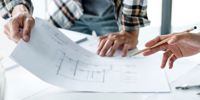 Architects interior designer hands working with Blue prints and Architects interior designer hands working with Blue prints and documents for a home renovation for house design